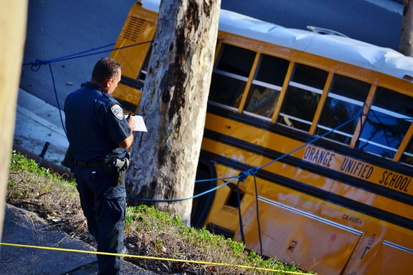 A California Highway Patrol officer takes notes of the school bus crash on late Thursday afternoon April 24, 2014.