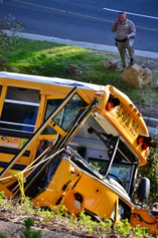 A California Highway Patrol officer talks on the phone near the crashed bus on Thursday afternoon.