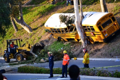 Workers break up a tree that fell as the result of a school bus crashing into a tree in Anaheim Hills in April 2014, resulting in about a dozen injuries.