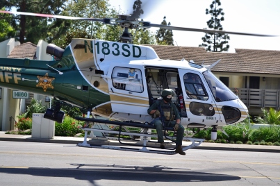 An Orange County Sheriff's helicopter with armed SWAT officers on both ledges takes off to search for an allegedly armed suspect in Tustin.